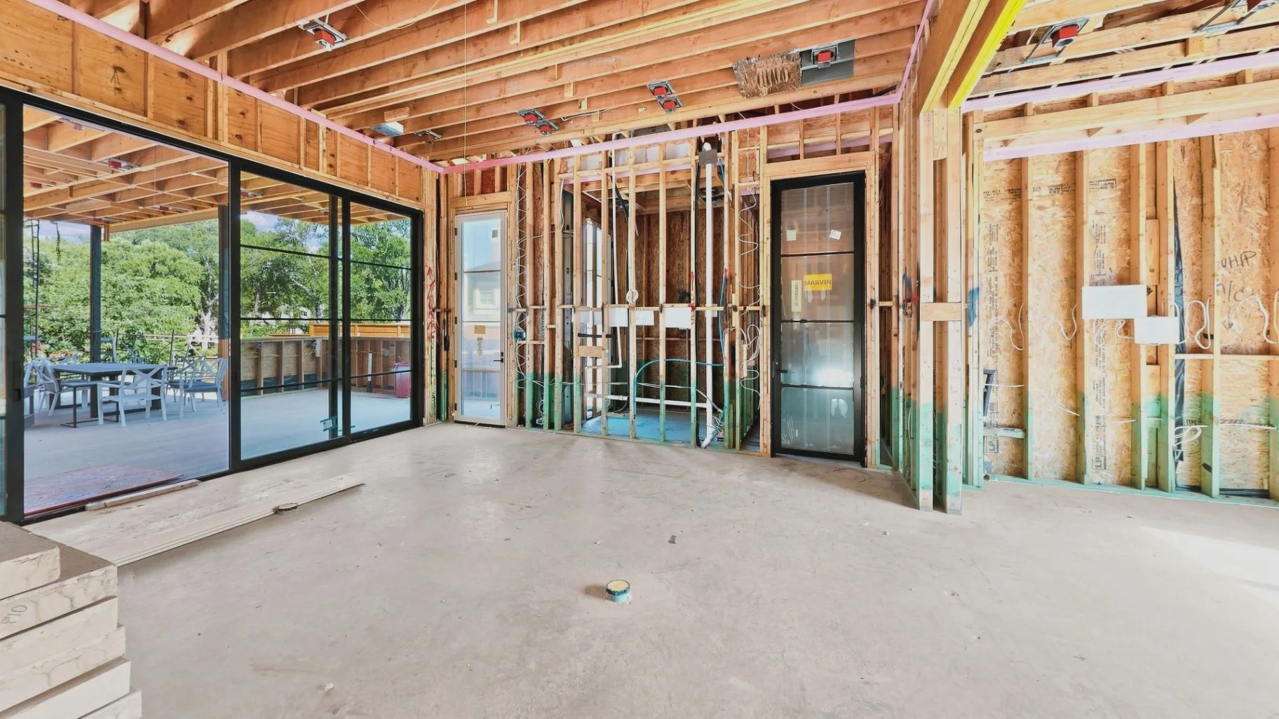 Construction interior showing exposed framing, rough-in work, and unfinished conditions